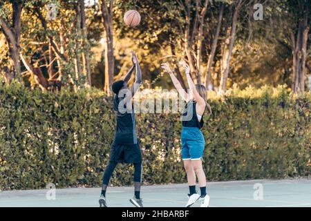 Zwei Freunde kämpfen um einen Ball, während sie in einem Basketballspiel springen Stockfoto