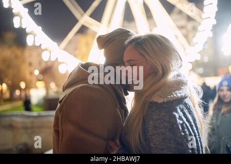 Junge romantische Paar in der Liebe mit magischen Lichtern an Weihnachten Stockfoto