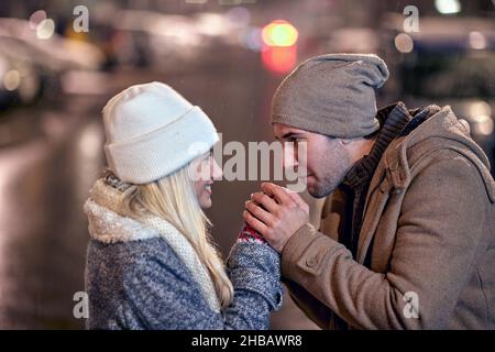 Kalte verschneite Nacht. Lächelnder Mann und Frau im Winter im Freien Stockfoto