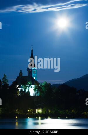 Supermoon, sichtbar über dem Kirchturm der wunderschönen Inselkirche der Mariä-Himmelfahrt, Bleder See, Slowenien. Aufgenommen am Abend des Sonntags Juni Stockfoto