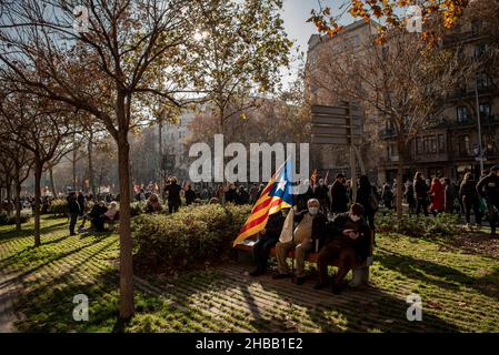 Barcelona, Spanien. 18th Dez 2021. Männer sitzen mit einer katalanischen Fahne für die Unabhängigkeit, während sich die Menschen in Barcelona versammeln, um das Bildungssystem zu unterstützen, das das Erlernen der katalanischen Sprache in den Schulen Kataloniens garantiert. Quelle: Jordi Boixareu/Alamy Live News Stockfoto