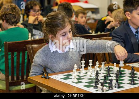 Intelligente Spiele. Ein Kind spielt Schach. Mädchen und ein Schachbrett. Strategie. Logisches Denken. Kleines Mädchen spielt Schach Stockfoto