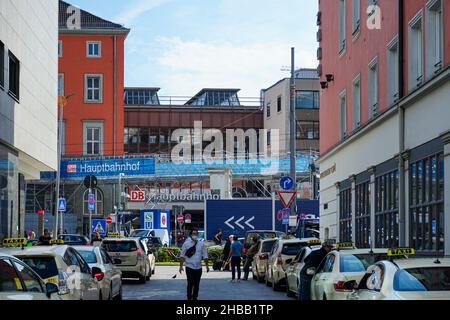 In einer Seitenstraße des Münchner Hauptbahnhofs warten zahlreiche Taxis auf Passagiere.Ein Mann mit Corona-Schutzmaske geht mitten auf der Straße Stockfoto