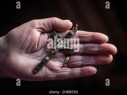 Rottweil, Deutschland. 17th Dez 2021. Eine alte Frau hält ein altes Kreuz in der Hand. Kredit: Silas Stein//dpa/Alamy Live Nachrichten Stockfoto