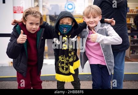 Die jungen Sutton United-Fans Max Ford (8 Jahre), Aiden Lawlee (10 Jahre) und Vinnie Joe (9 Jahre) (links-rechts) vor dem zweiten Spiel der Sky Bet League im VBS Community Stadium, London. Bilddatum: Samstag, 18. Dezember 2021. Stockfoto