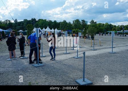 Eine Frau überprüft den Impfpass von den Besuchern am Eingang eines Corona-Testzentrums auf einem Kulturfestplatz in München. Stockfoto