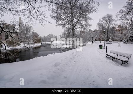 Bedeckt mit Schneebank und Kanal im Winterpark. Winterlandschaft in verschneiten Park mit schönen kleinen Kanal und mit Schneebäumen bedeckt. Stockfoto