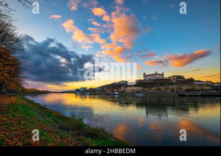 Sonnenuntergang über der Burg Bratislava, dem slowakischen parlament und der Donau in der Slowakei Stockfoto