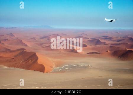 Schöne Luftaufnahme der namib Wüste von einem kleinen Flugzeug aus. Meer aus Sanddünen, sonniger Tag. Ein weiteres Flugzeug fliegt. Namibia. Afrika Stockfoto