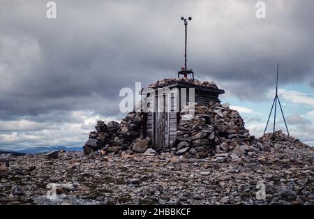 Archivbild Sommer 1989. Holzhütte mit Windmesser, geschützt durch Geröllsteinmauer auf dem Gipfel des Ben Nevis, dem höchsten Berg Großbritanniens Stockfoto