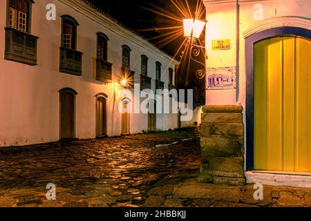 Kopfsteinpflasterstraße und Spiegelungen in Pfützen in der historischen Stadt Paraty während einer regnerischen Sommernacht Stockfoto