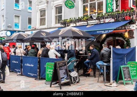 Cork, Irland. 18th Dez 2021. Das Stadtzentrum von Cork war am letzten Samstag vor Weihnachten sehr voll. Tausende von Menschen gingen in die Geschäfte, um Weihnachtsgeschenke zu kaufen, und der Verkehr war überall in der Stadt stationär. Le Chateau Bar war voll mit Trinkern. Quelle: AG News/Alamy Live News Stockfoto