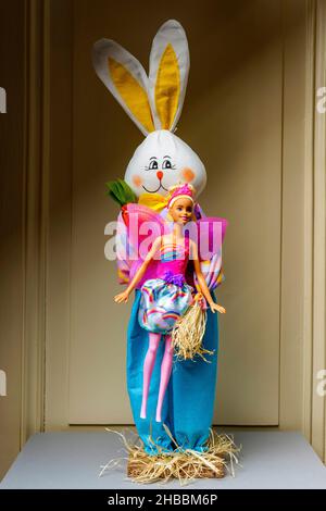 Gefülltes glückliches Kaninchen mit einer Barbie-Puppe mit rosa Flügeln, Stockfoto