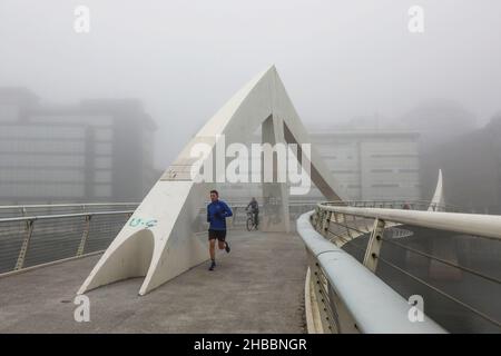 Glasgow, Großbritannien. 18th Dez 2021. Am frühen Morgen wurden Pendler von einem frostigen Nebel verwöhnt, der eine surreale Landschaft über dem Fluss Clyde und seinen Brücken, insbesondere der Tradeston Bridge (auch bekannt als die Squinty Bridge) und der Portland Suspension Bridge, schuf. Kredit: Findlay/Alamy Live Nachrichten Stockfoto