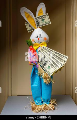 Gefülltes glückliches Kaninchen mit einem Fächer von hundert US-Dollar-Banknoten und 1 einer US-Dollar-Banknote zwischen den Ohren, Stockfoto