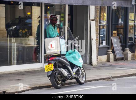 CAMBRIDGE, VEREINIGTES KÖNIGREICH - 18. Sep 2021: Eine Aufnahme des Deliveroo-Fahrers, der vor einem Restaurant auf seine Bestellung wartet Stockfoto