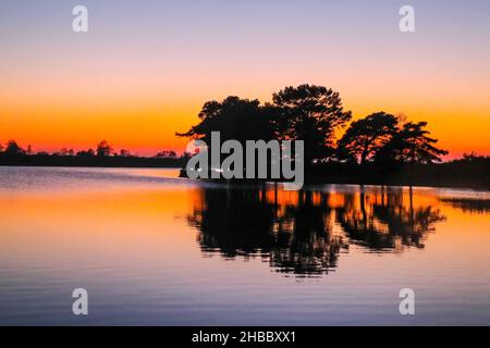 New Forest, Hampshire, Großbritannien 18. Dezember 2021 Hatchet Pond herrlicher Sonnenuntergang. Paul Quezada-Neiman/Alamy Live News Stockfoto