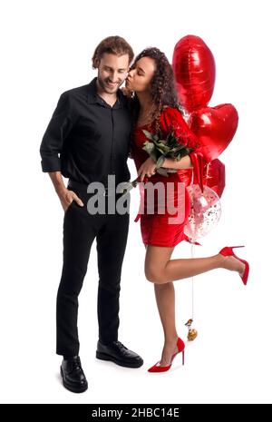Glückliche junge Frau küsst ihren Freund auf weißem Hintergrund. Valentinstag-Feier Stockfoto