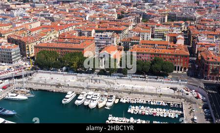 Luftaufnahme von Seehafen und Hafen mit Luxusyachten in Port de Nice in Frankreich an einem sonnigen Sommertag. Blick von oben auf weiße Boote, die Stadt und das Meer. Stockfoto