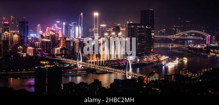 CHONGQING, CHINA - 29. Oktober 2019: Eine Panoramaaufnahme eines Flusses, der von Gebäuden und Brücken umgeben ist, in Chongqing bei Nacht in China Stockfoto