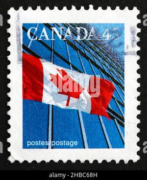 KANADA - UM 1991: Eine in Kanada gedruckte Marke zeigt die kanadische Flagge und das Gebäude, um 1991 Stockfoto