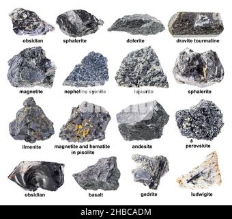 Set aus verschiedenen rohen schwarzen Mineralien mit Namen, die auf weißem Hintergrund ausgeschnitten sind Stockfoto