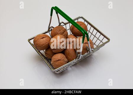 Walnussfrüchte liegen in einem kleinen Eisenkorb. Hochwertige Fotos Stockfoto