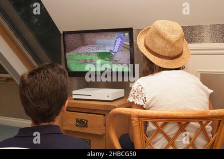 Ein Bruder und eine Schwester spielen das Computerspiel Minecraft auf einer Xbox, aufgenommen am 13. August in Wool, Dorset, Großbritannien Stockfoto