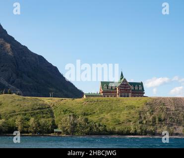 Blick auf das Prince of Wales Hotel auf einem Hügel vom Waterton Lake mit einem Teil des Mount Crandell im Hintergrund. Stockfoto