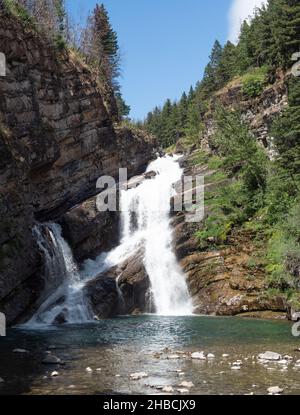 Cameron Falls, die sich im Sommer über felsige Klippen am Rande des Waterton Village im Waterton Lakes National Park, Alberta, Kanada, ergießen. Stockfoto