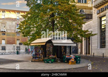 Ein Zeitungskioské vor der Banca Nazionale del Lavoro auf dem Largo Eros Lanfranco Platz an einem sonnigen Herbsttag, Genua, Ligurien, Italien Stockfoto