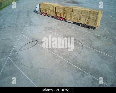 Geparkter LKW mit Heuballen aus der Luft an einem Rastplatz auf der Straße, in der Nähe von Melbourne, Victoria, Australien. Stockfoto