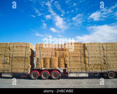 Geparkte LKW-Seitenansicht mit eingewickelten Heuballen an einem Rastplatz am Straßenrand, blauem Himmel und Wolken, in der Nähe von Melbourne, Victoria, Australien. Stockfoto