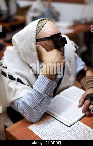 Religiöser Jude mit Tefillin auf der Stirn und einem hohen Kopf beim Beten Stockfoto