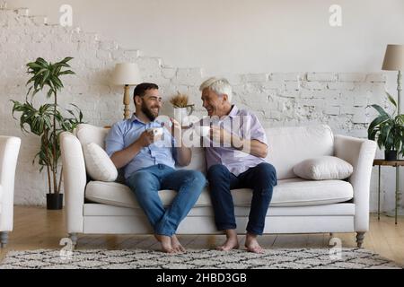 Unbeschwerte entspannte junge Mann und alten Vater zu Hause reden. Stockfoto