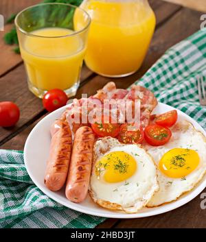 Englisches Frühstück - Toast, Ei, Speck und Gemüse im rustikalen Stil auf hölzernen Hintergrund Stockfoto