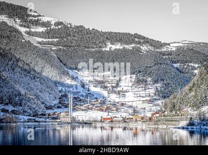 Uzungol landschaftlich schönen See-Panorama in Verbindung mit traditionellen türkischen Moschee und Wohnhäusern und Wald im Hintergrund.Winter Urlaub in der Türkei Stockfoto