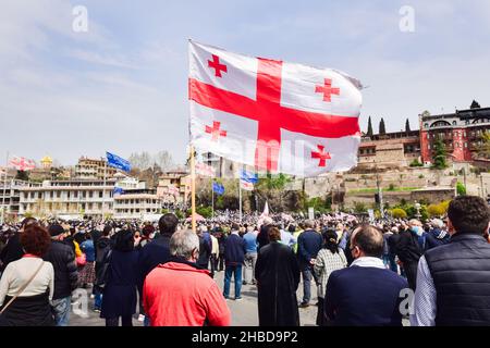 Tiflis, Georgien - 9th. april 2021: Person hält georgische Flagge auf der Straße in friedlicher Protest. „Tbilisi Tragödie“-Jubiläumsdemonstration. Stockfoto