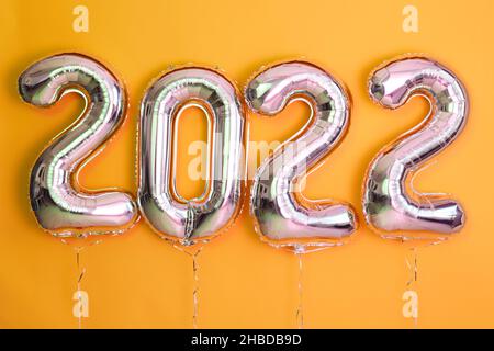 Farbige Kugeln Neujahr 2022 Feier Objekt Render Ballon mit Band gelben Hintergrund Stockfoto