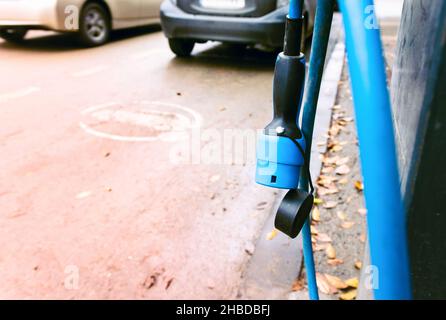 Nahaufnahme des Elektroautos Ladeschlauchende leerer Parkplatz für Elektroautos. Stockfoto