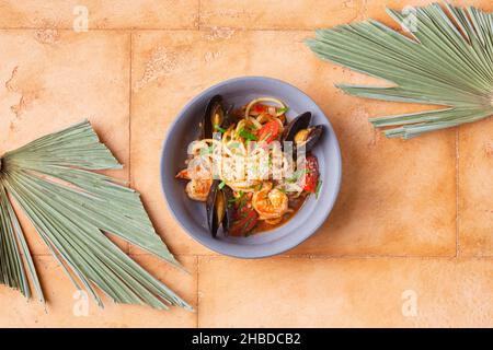 Italienische Pasta mit Muscheln Garnelen Tomatenkirsche und Käse in grauer Platte Stockfoto