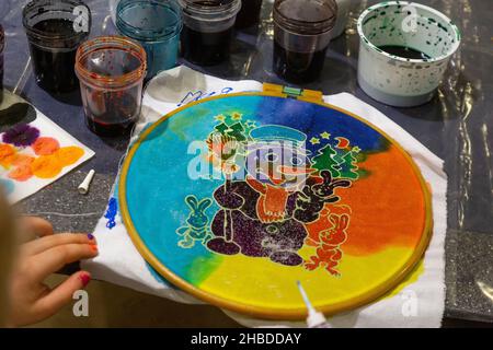 Moskau, Russland. 18th. Dezember 2021 Ein Mädchen zieht einen Schneemann mit Stofffarben während einer Meisterklasse in Moskau am Silvesterabend, Russland Stockfoto