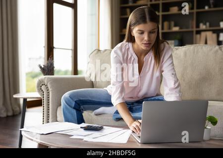 Ruhige attraktive junge Frau in Weihnachtshut mit Telefon. Stockfoto