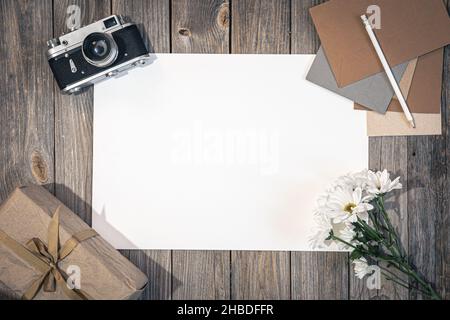 Flacher Hintergrund mit Retro-Kamera und Buchstaben auf Holzoberfläche. Stockfoto