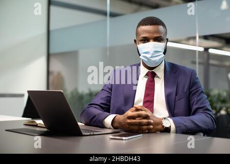Porträt eines afroamerikanischen Managers in einer Gesichtsmaske im Büro Stockfoto