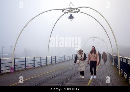 Southport, Merseyside. Wetter in Großbritannien; 18th. Dezember 2021. Dichter Nebel nach der kältesten Nacht des Jahres in der nordwestlichen Küstenstadt. Die Bewohner des Resorts können bei kalten, nebligen Bedingungen morgens an der Strandpromenade leichte Übungen machen. Kredit; MediaWordImages/AlamyLiveNews Stockfoto