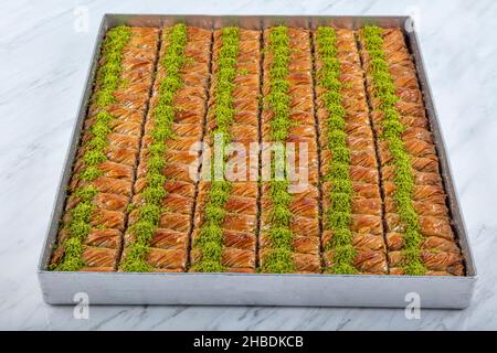 Köstliches türkisches Pistazien-Baklava-Dessert. Traditionelles türkisches Dessert antep Baklava mit Pistazien, ramadan oder Feiertagsdesserts in Tablett auf Marmor f Stockfoto