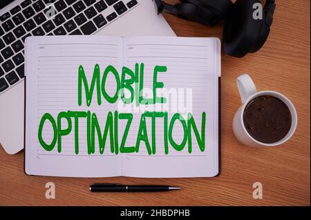 Handschriftschild Mobile Optimierung. Geschäftskonzept Site Content für Handheld- oder Tablet-Geräte neu formatiert Blank Notizpad Laptop mit Stift und Stockfoto
