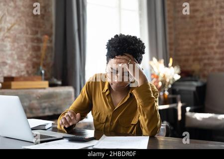Unglückliche junge afroamerikanische Frau mit finanziellen Problemen. Stockfoto