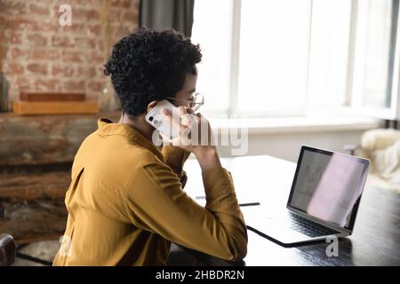 Fokussierte afroamerikanische Geschäftsfrau Multitasking im modernen Büro. Stockfoto
